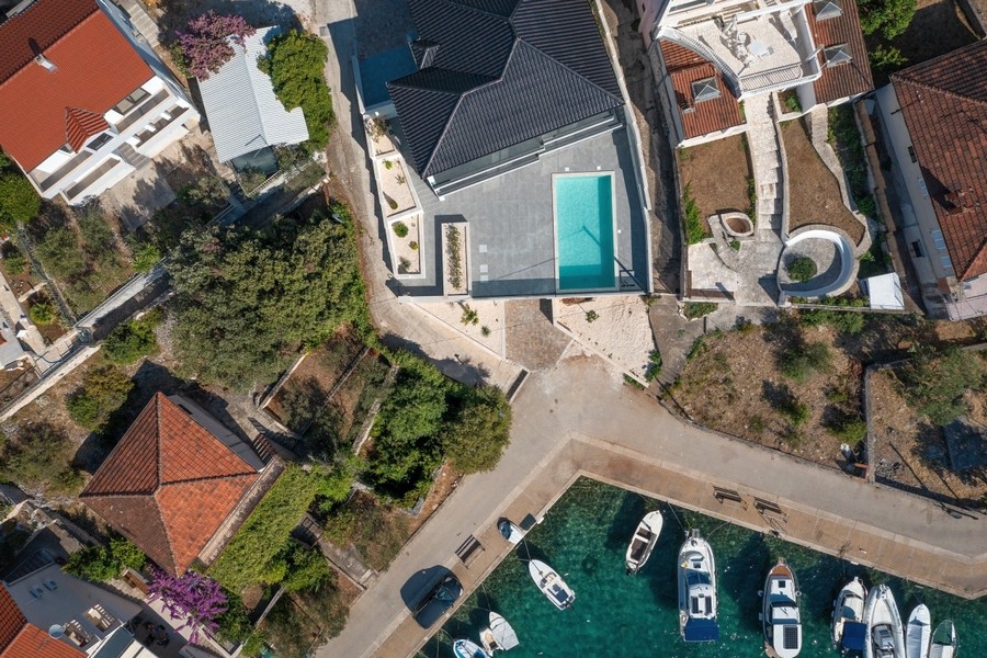 Flygfoto över villa med pool nära havet