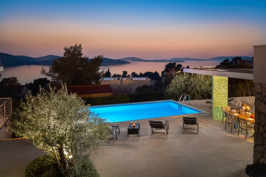 Pool med sommarkök och havsutsikt på kvällen