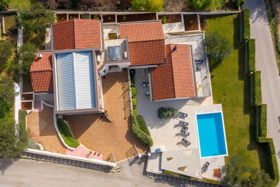Flygfoto över villa, pool och trädgård