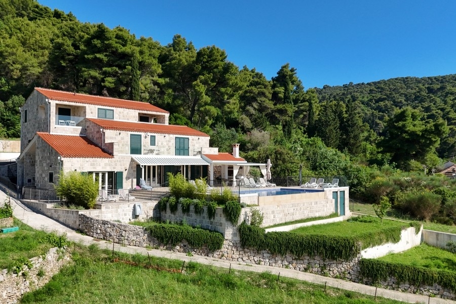 Villa med stenfasad, trädgård och pool