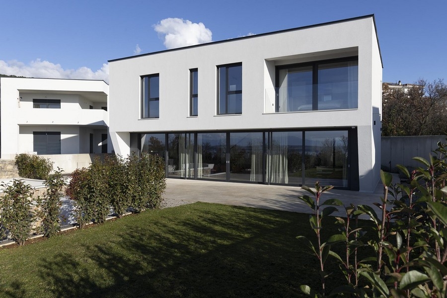 Trädgård med gräsmatta och glasfront