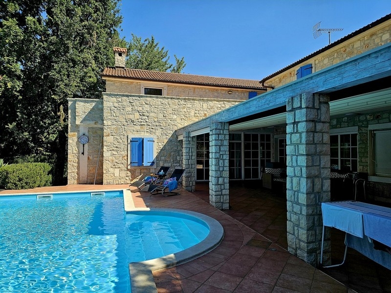 Pool med solstolar på den täckta terrassen