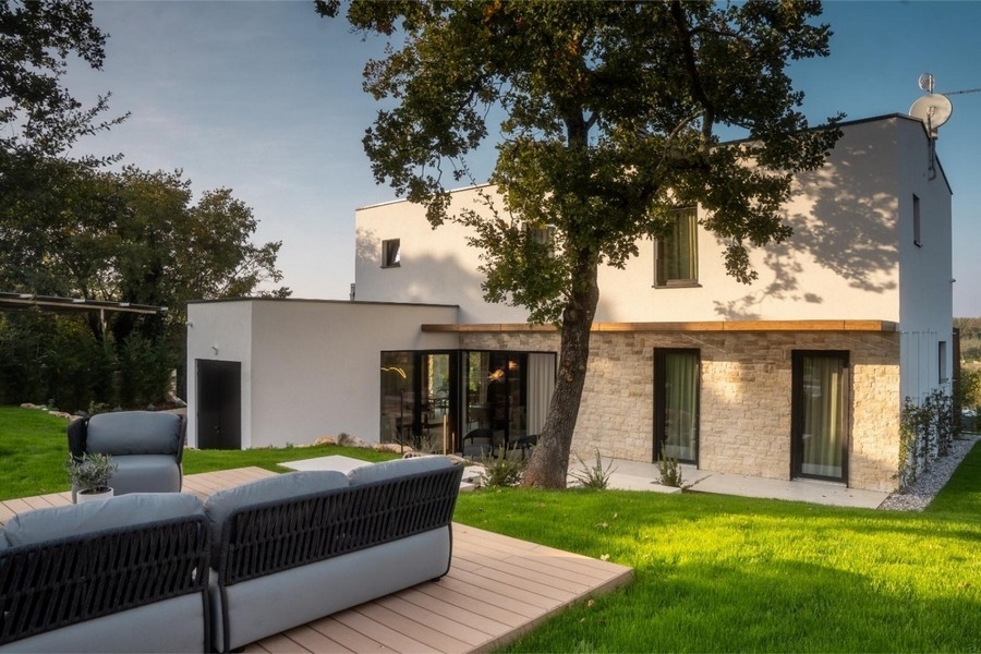 Villa med stenfasad och lounge på trädäck