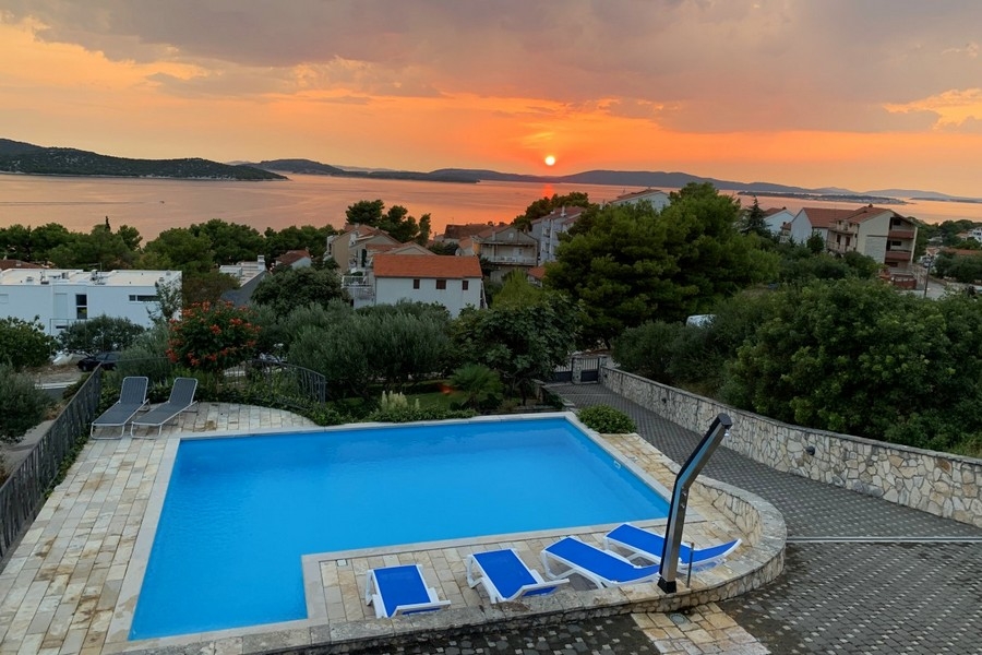 Pool med havsutsikt vid solnedgången i Kroatien