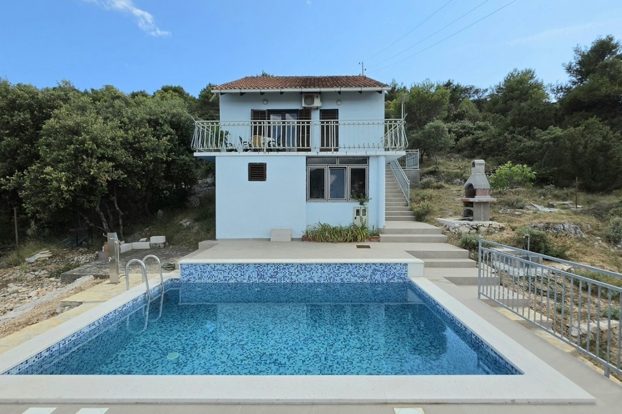 Exteriör vy av huset med pool och trädgård