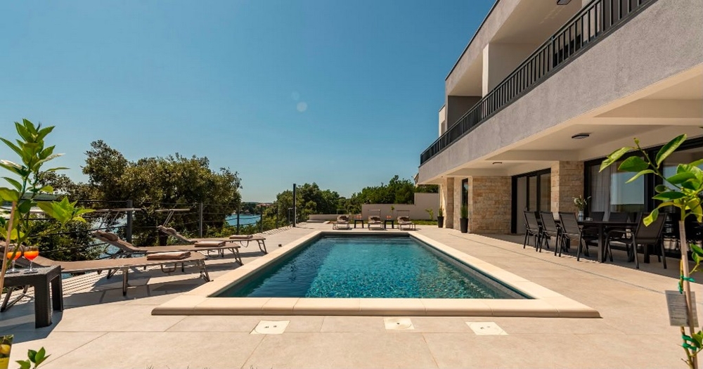 Pool med terrass framför villan