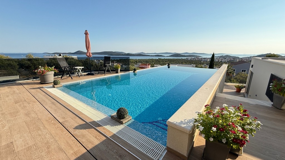 Uppvärmd pool med solterrass och havsutsikt