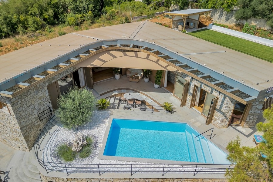 Flygfoto över villa med pool och innergård
