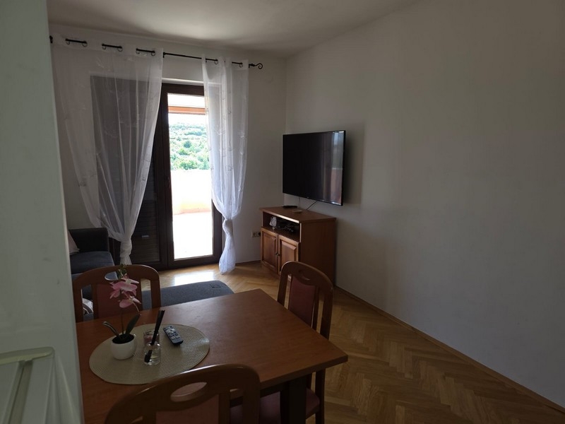 Vardagsrum med bord, tv och altandörr
