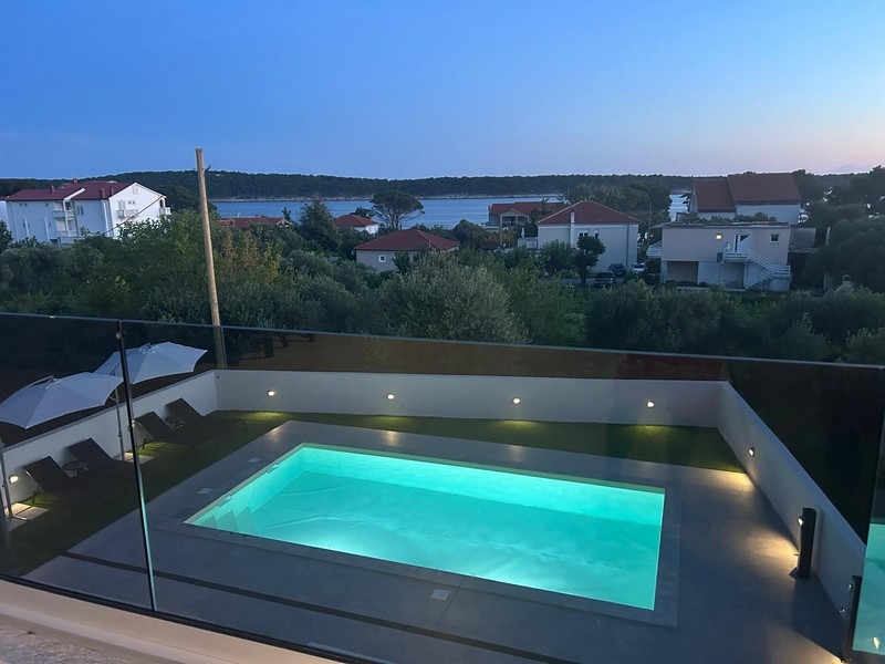 Upplyst pool med utsikt över Banjol och bukten