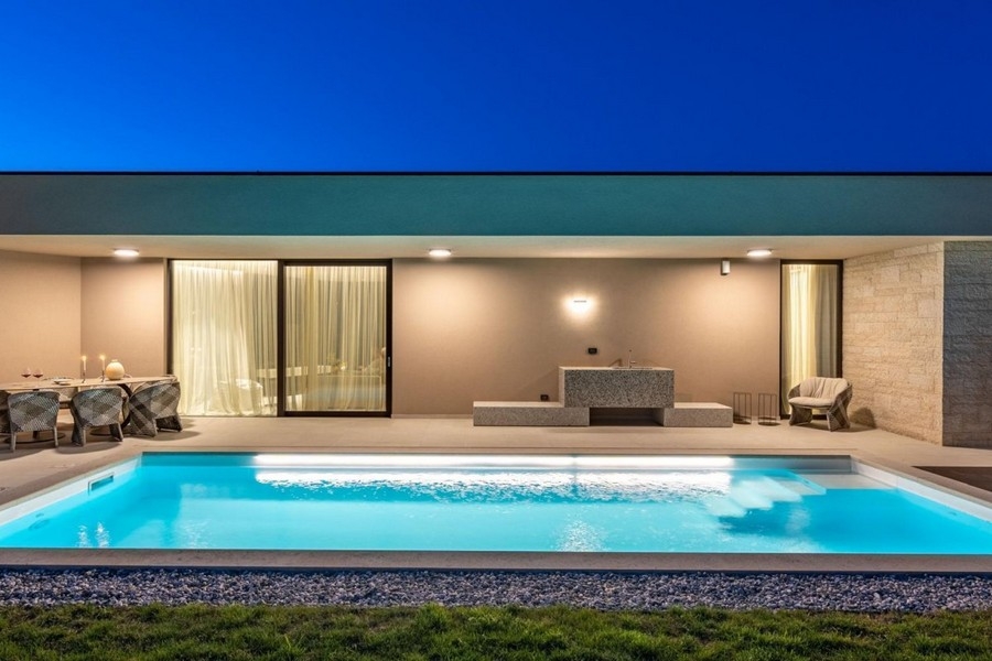 Upplyst pool och terrass i villan nära Porec på kvällen