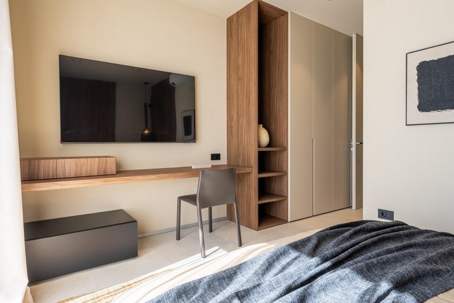 Sovrum med skrivbord, TV och inbyggd garderob
