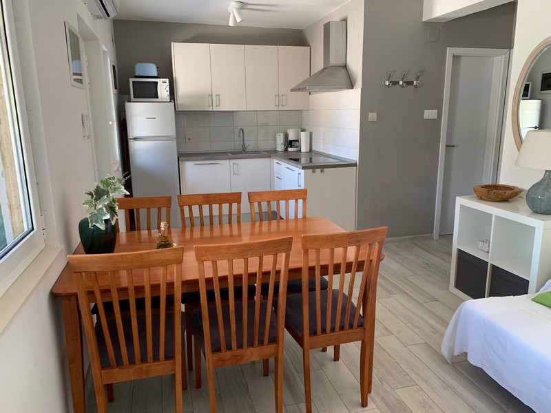 Kök med matbord i en lägenhet i huset i Povlja på Brac