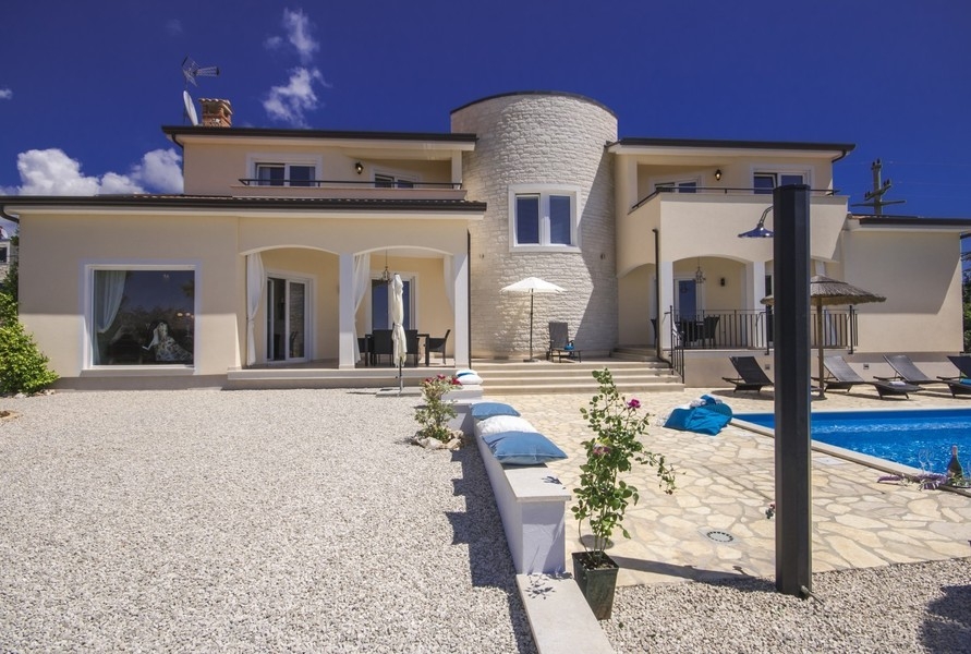 Pool med solstolar vid villan nära Porec