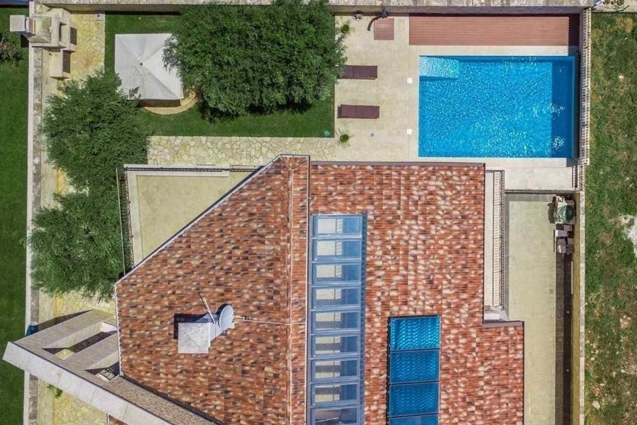 Flygfoto över huset, trädgården och poolen