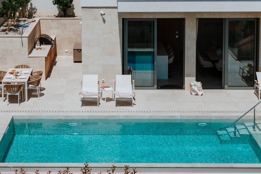 Pool med solstolar på terrassen