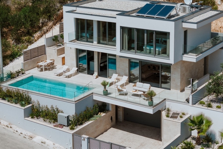 Exteriör vy av villan med pool och terrasser