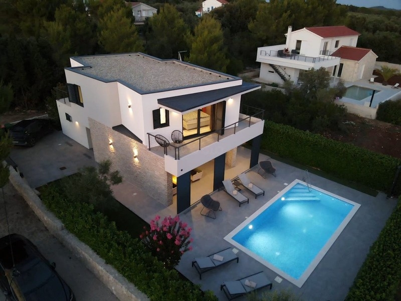 Flygfoto över villan med pool och trädgård