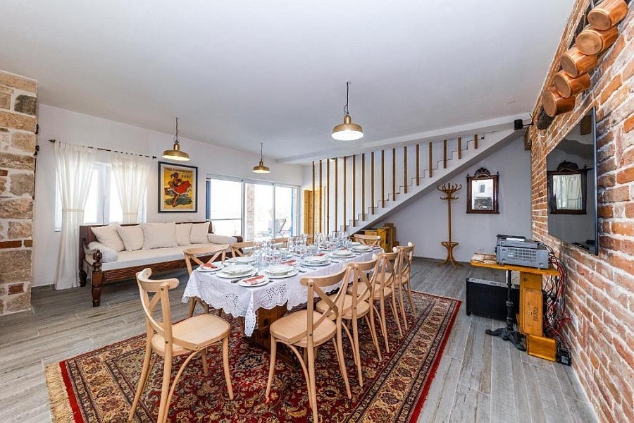 Vardagsrum med matbord och trappa till övervåningen