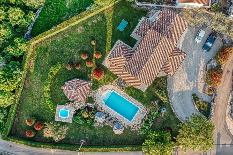 Flygfoto över hus, pool och trädgård med häck