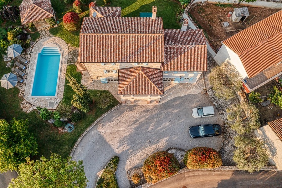 Flygfoto med hus, pool och infart med två bilar