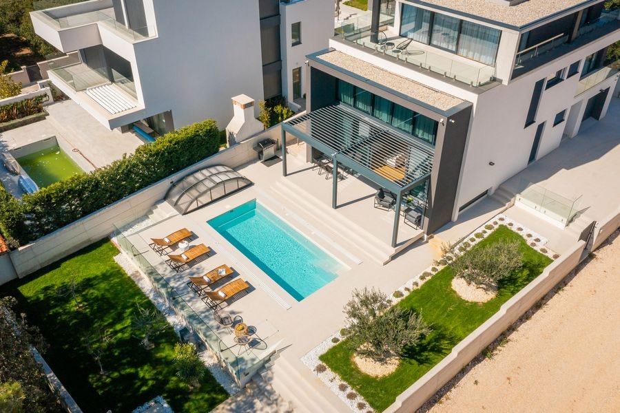 Flygfoto över villan med pool och trädgård