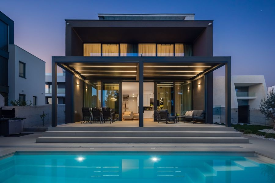 Villa på kvällen med belyst pool