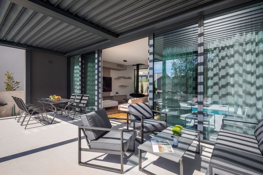 Terrass under pergolan med loungeyta