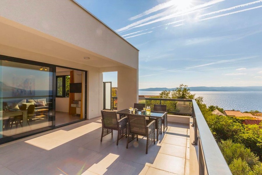 Terrass med matbord och utsikt över havet