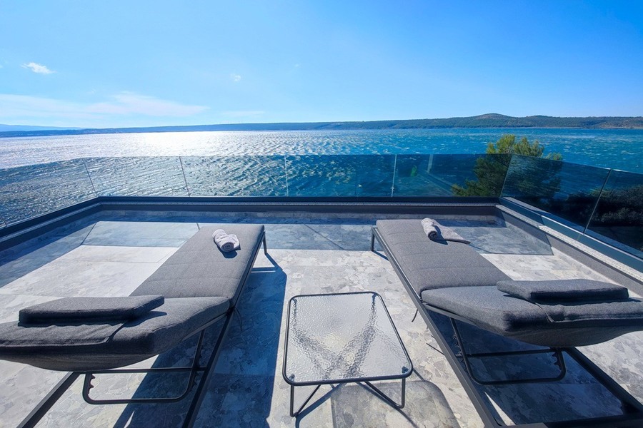 Terrass med solstolar över havet