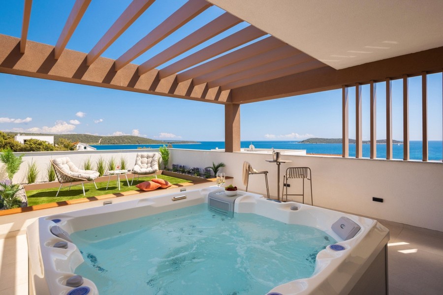 Jacuzzi under pergola med havsutsikt
