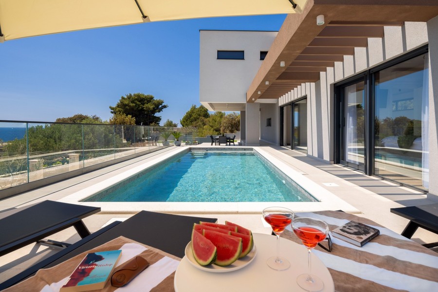 Pool med solstolar och utsikt över havet