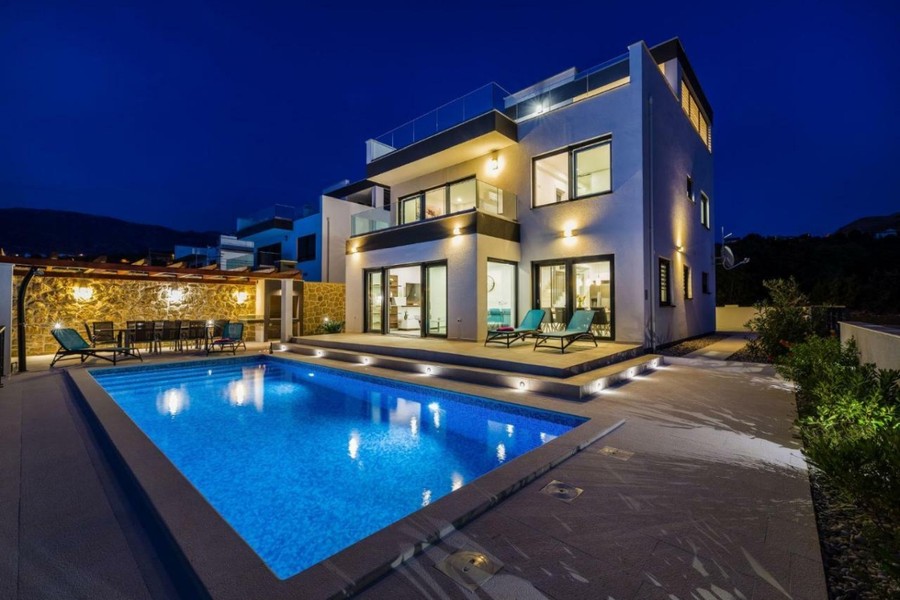Villa på kvällen med upplyst pool