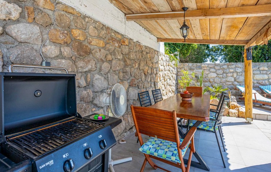 Överdäckad terrass med grill och matbord