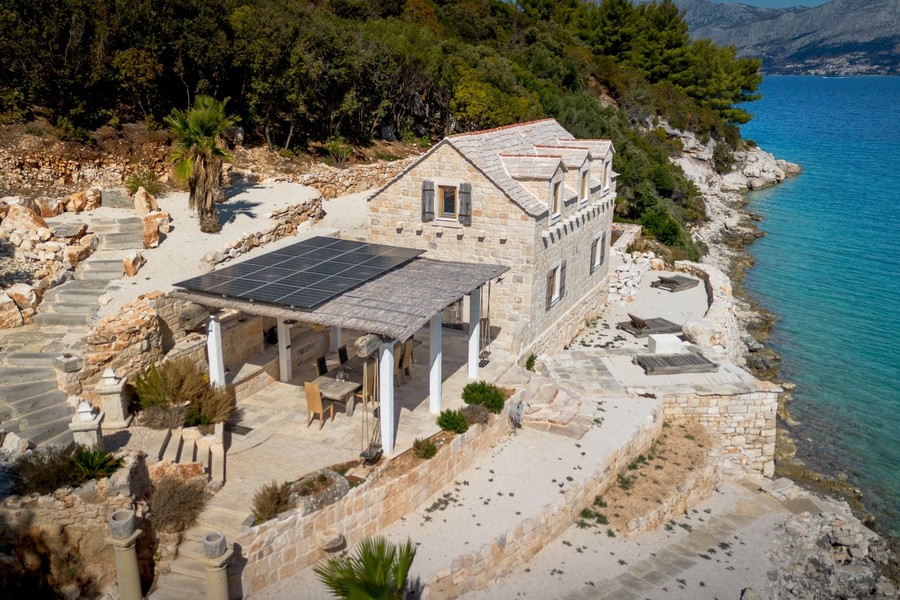Flygfoto av stenhuset med terrass vid stranden