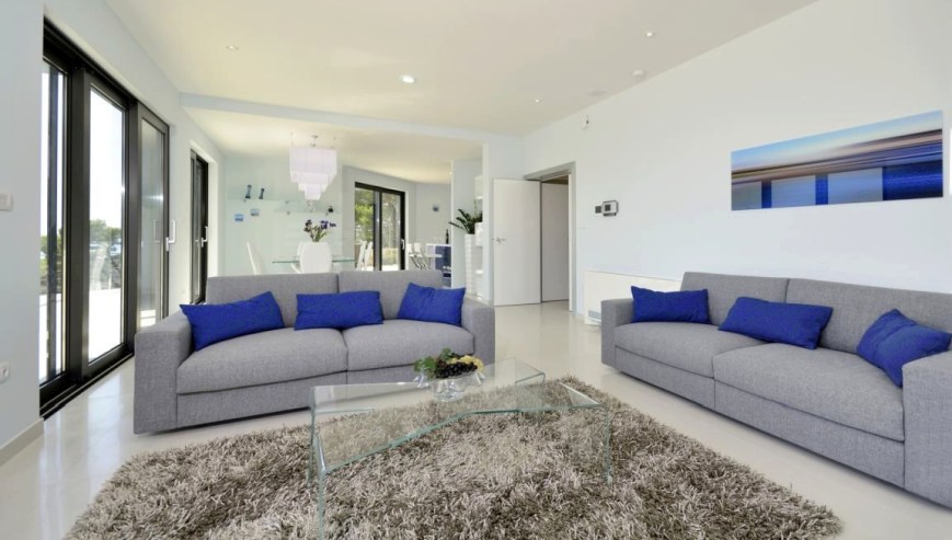 En titt in i det rymliga vardagsrummet i den moderna lyxvillan med havsutsikt i Kroatien