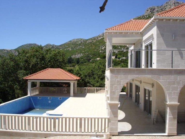 Uteområde med pool och terrasser.