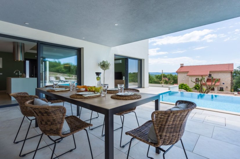 Täckt terrass och utomhuspool.